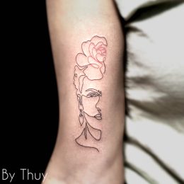 Rose et visage en ligne fine sur le bras