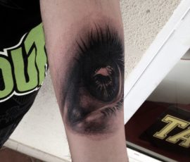 Œil réaliste en noir et gris sur l'avant-bras
