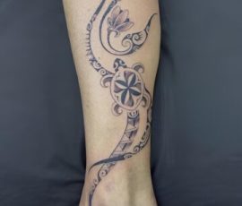 Volutes polynésiennes, tortue et fleurs sur la jambe