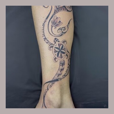 Volutes polynésiennes, tortue et fleurs sur la jambe
