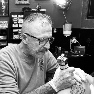 Adrien, tatoueur à Nouméa, tatouant un motif ornemental dans son studio