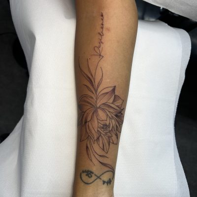 Lotus et fine ligne sur l'avant-bras — tatouage par Tony, Nouméa